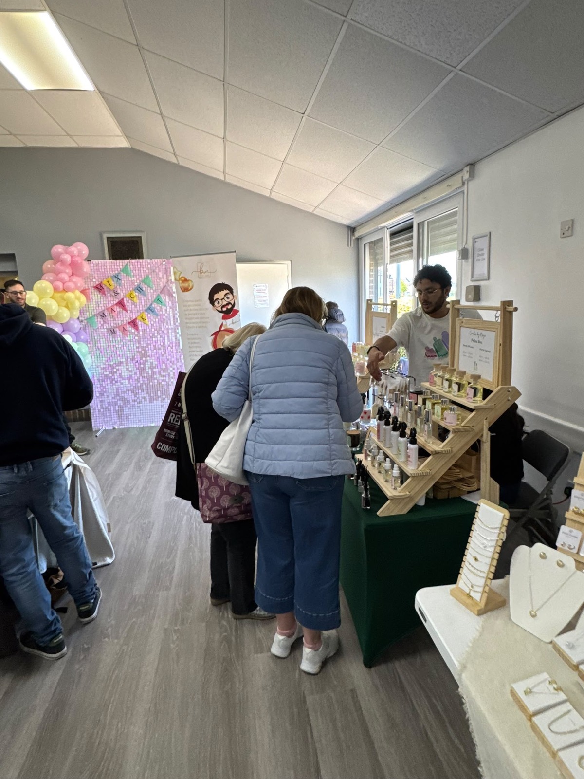 Visitors browsing candles and jewellery stalls