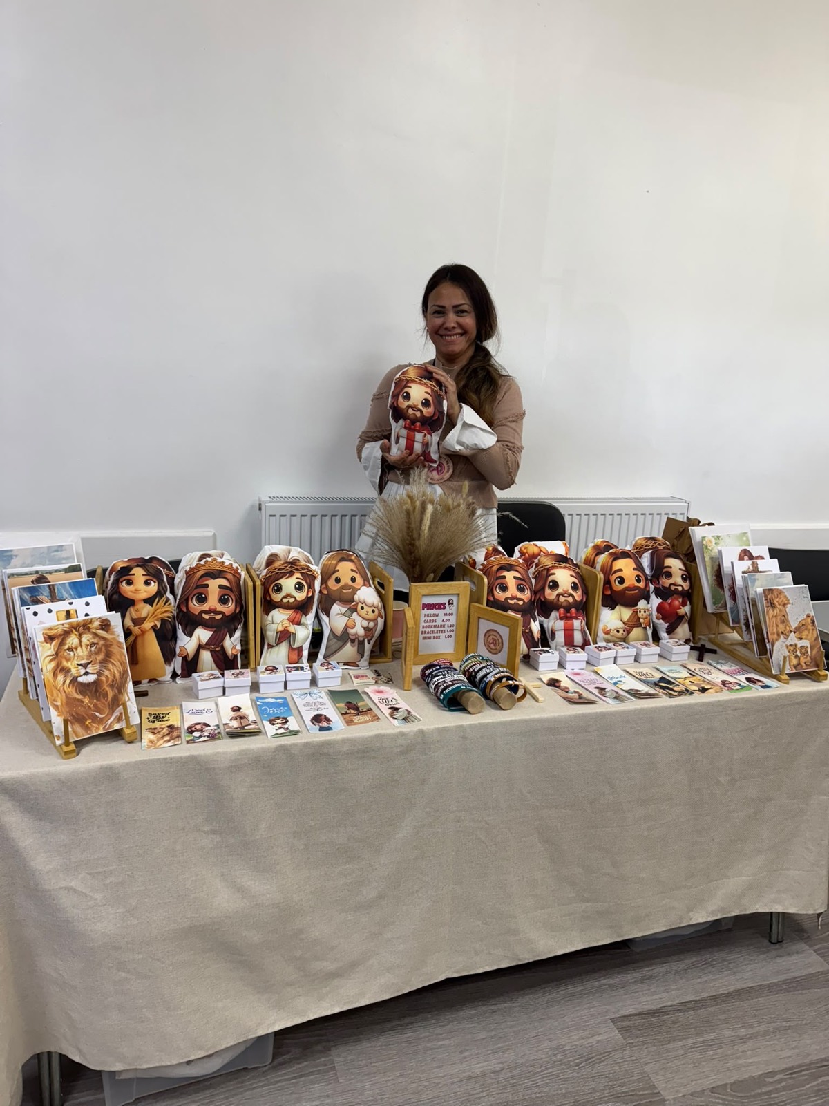 Maker showing a handmade doll at her toy stall